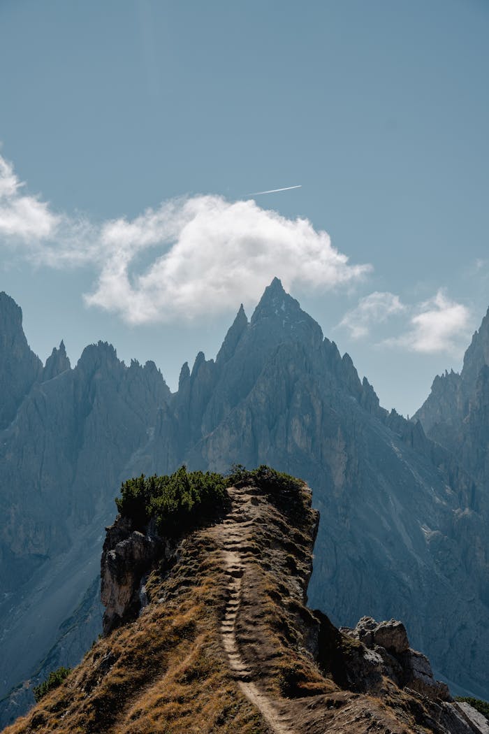 Breathtaking view of a mountain path leading into the Dolomites under a clear sky.